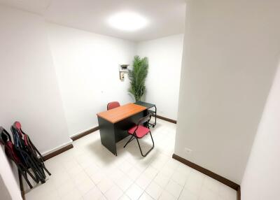 Small office with desk, chairs, and potted plant