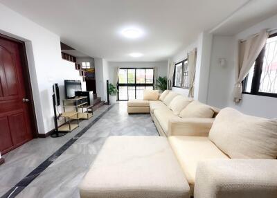 Spacious and modern living room with large windows and comfortable seating