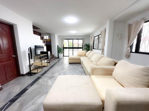 Spacious and modern living room with large windows and comfortable seating