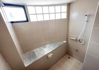 Modern tiled bathroom with shower and window lighting