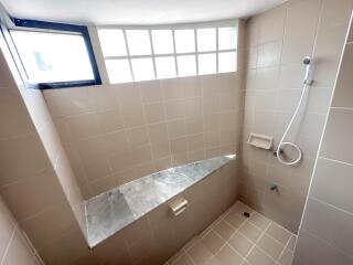 Modern tiled bathroom with shower and window lighting