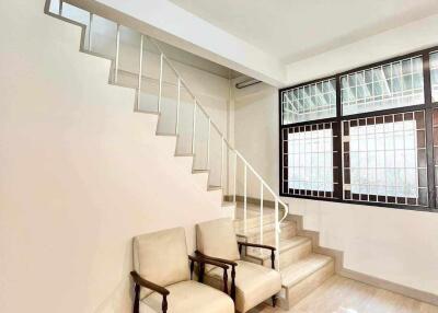 Minimalist living space with staircase and two chairs