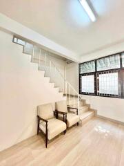 Minimalist living space with staircase and two chairs