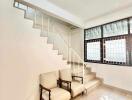 Minimalist living space with staircase and two chairs