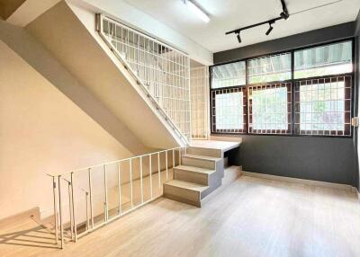 Living room with staircase and large windows