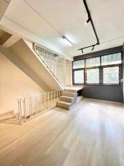 Living room with staircase and large windows