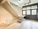 Living room with staircase and large windows