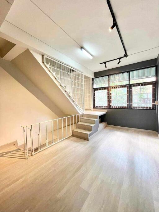 Living room with staircase and large windows