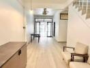 Minimalist living area with light wood flooring and staircase