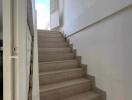 Interior staircase with wooden steps and white walls