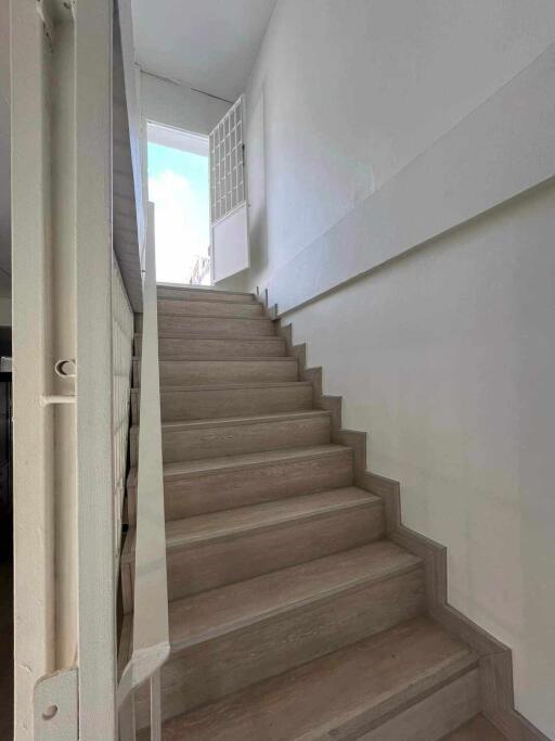 Interior staircase with wooden steps and white walls