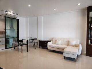 Modern living room with dining area and glass partition to kitchen