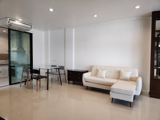 Modern living room with dining area and glass partition to kitchen