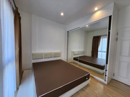 Bedroom with large mirror and brown bed