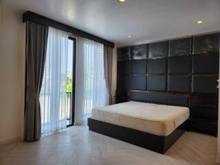 Modern bedroom with large window and dark wood furnishings