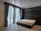 Modern bedroom with large window and dark wood furnishings