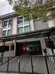 Front exterior view of a multi-story house with a gated entrance