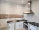 Modern kitchen with stainless steel range hood and black countertops