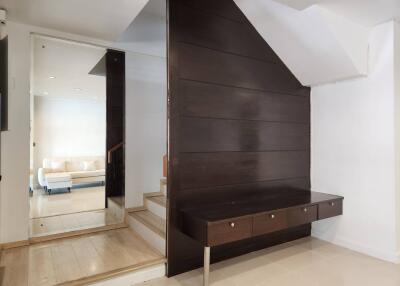 Modern living space with wooden stairs and reflective wall