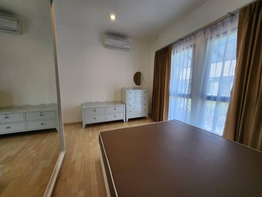 Spacious bedroom with large window and mirrored wardrobe