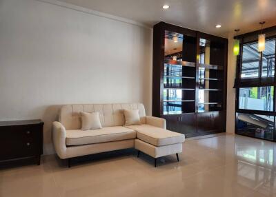 Modern living room with a sofa, cabinet, and hanging lights