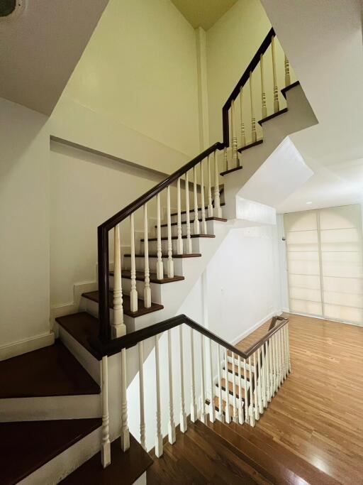 Staircase with wooden steps and white balusters