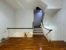 Stairway with wooden floor and white walls leading to an upper and lower level