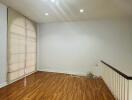 Unfurnished living room with hardwood flooring and a large window