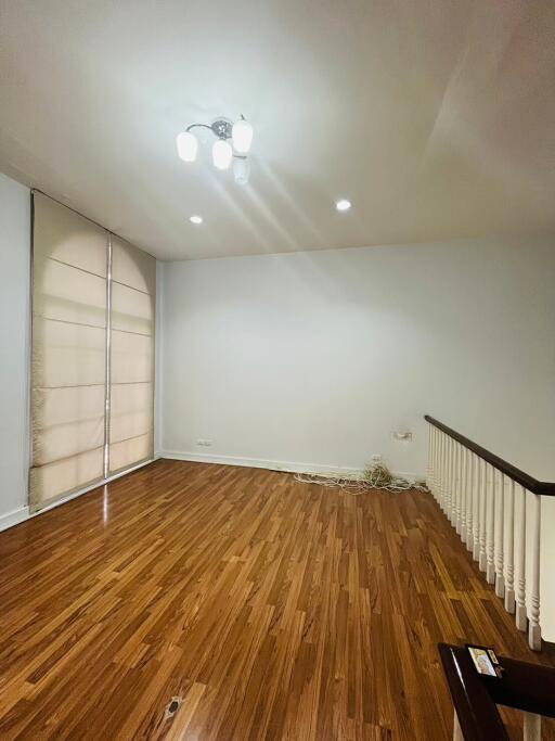 Unfurnished living room with hardwood flooring and a large window