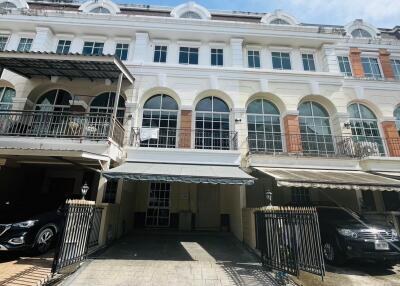 Front view of a multi-story building with multiple carports