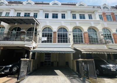 Front view of townhouse with multiple levels and carports