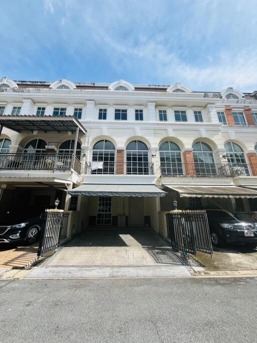 Front view of townhouse with multiple levels and carports