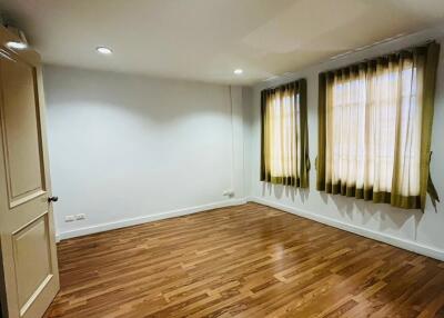 Empty bedroom with wooden flooring and two windows