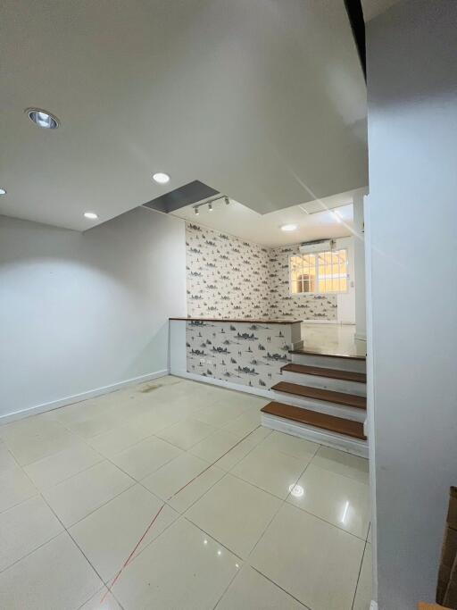 Interior view of main living area with staircase and decorative wall