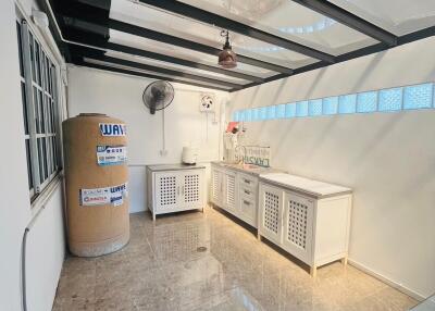 Spacious utility room with large water heater and countertop workspace