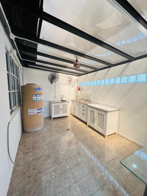 Spacious utility room with large water heater and countertop workspace