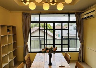 Well-lit dining room with modern lighting and large windows