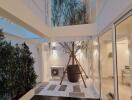 Modern indoor courtyard with glass walls and potted trees