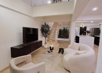 Modern living room with stylish furniture and ascending staircase