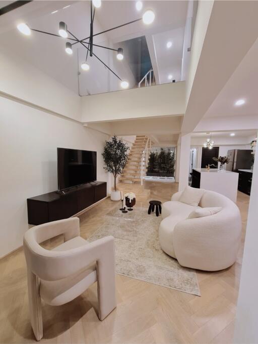 Modern living room with stylish furniture and ascending staircase