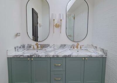 Modern bathroom with double vanity, marble countertop, and gold fixtures