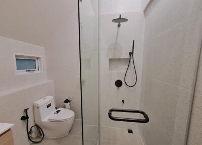 Modern bathroom with toilet, shower, and glass door