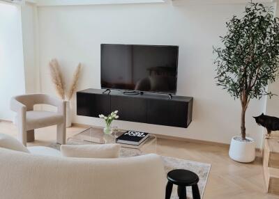 Modern living room with TV, chair, and cat