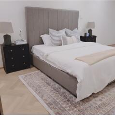 Modern bedroom with a neatly made bed, bedside tables, and lamps