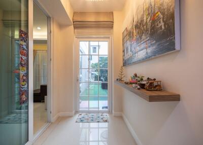 Hallway with decorative shelves and glass door