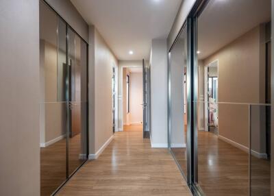 Spacious modern hallway with wooden flooring and mirrored closets