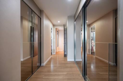 Spacious modern hallway with wooden flooring and mirrored closets