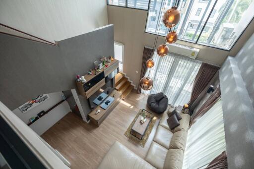 Contemporary high-ceiling living room with large windows and modern decor