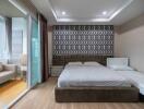 Modern bedroom with large bed, stylish wallpaper, and adjoining study area