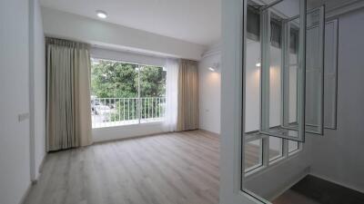 Spacious and bright living room with large window and mirrored wall